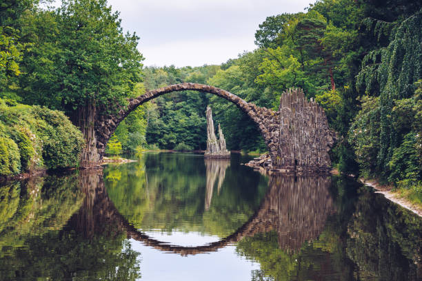 rakotz는 kromlau, 독일에서 (rakotzbrucke)로 알려진 악마의 다리 다리. 물에 다리의 반사 전체 동그라미를 만듭니다. - stone circle 뉴스 사진 이미지