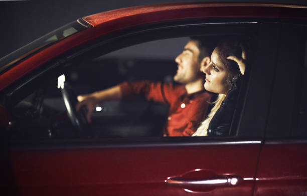 What a drive! Shot of a young couple traveling in a car together at night couple driving at night stock pictures, royalty-free photos & images
