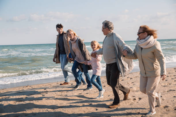 istock multigenerational family running on beach 887632672