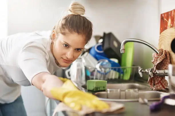 Cropped shot of a young woman cleaning her home