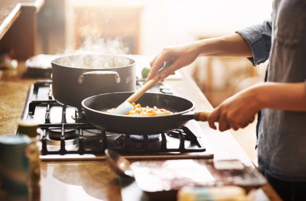 The start of something delicious Cropped shot of a young woman preparing a meal at home cooking pan photos stock pictures, royalty-free photos & images