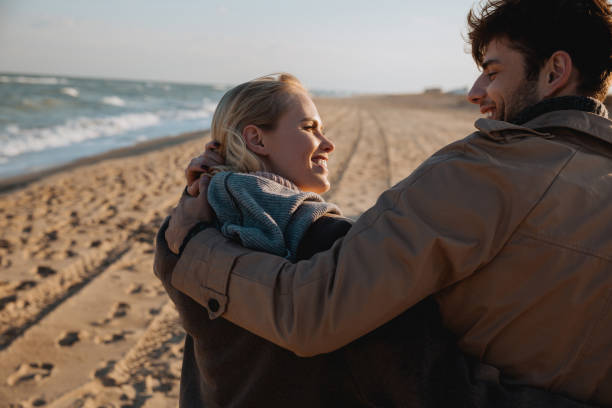 istock smiling couple embracing on seashore 887647244
