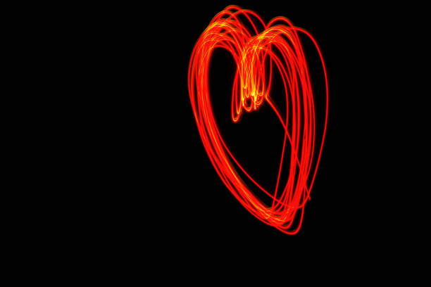 istock Light painting heart shape over black background 887650256
