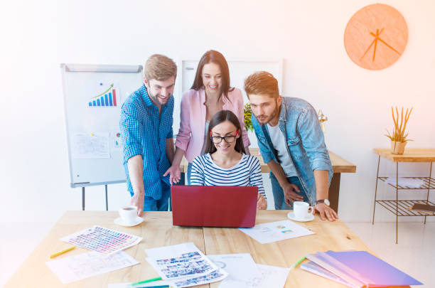 istock Creative business team at work. Group of young business people working and communicating together while sitting at their working places in office 887651258