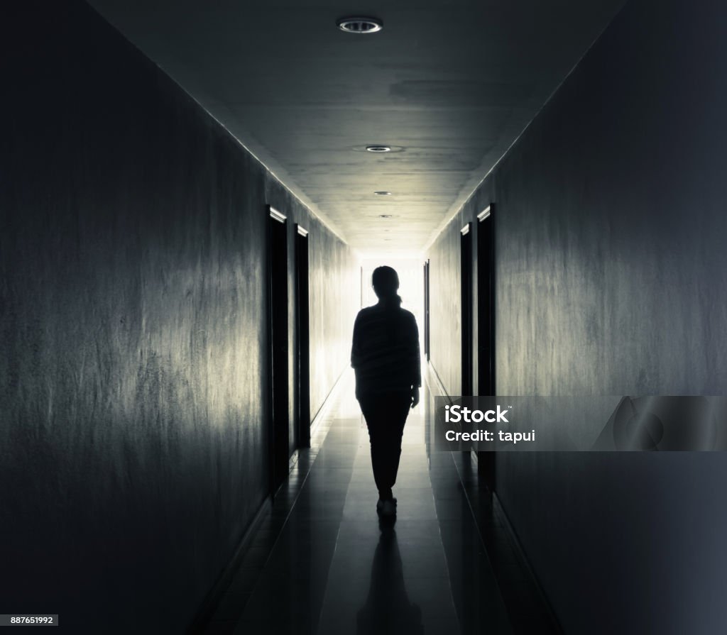 Women are walking alone in the dark.Light at the end of the tunnel concept Women Stock Photo