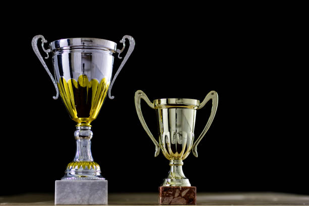 prize, a cup standing on the table. Cup award on a black background. Wooden table