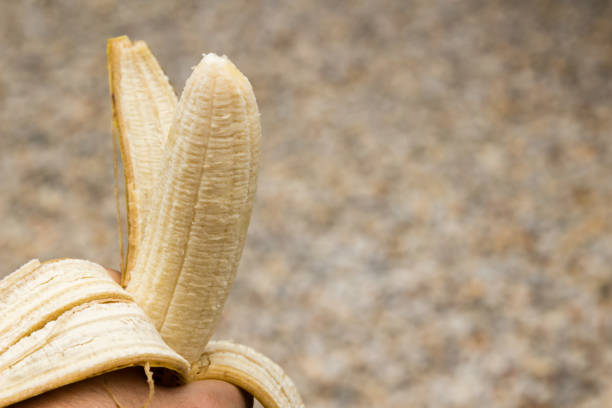 istock A hand holding a peeled banana 887659780