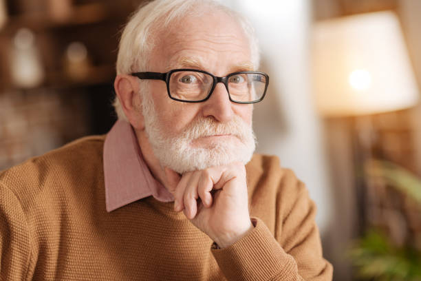 istock White-haired elderly man resting his chin on fist 887664258