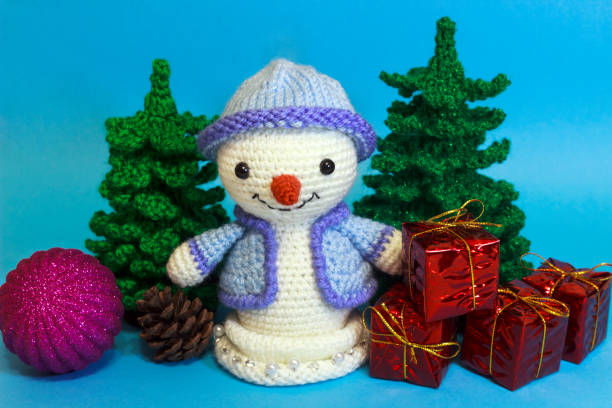 istock snowmen next to a Christmas tree among toys on a blue background 887670664
