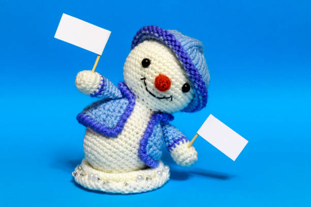 istock a snowman with signs in both hands bent down 887670668