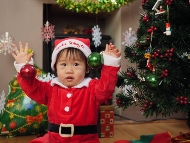 istock baby girl  decorating Christmas tree 887680926