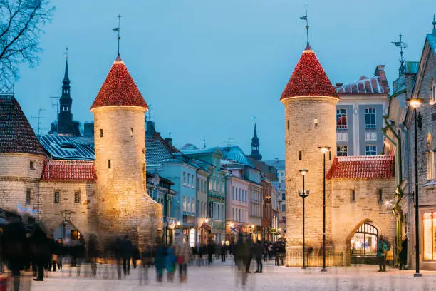 Photo of Tallinn, Estonia. Famous Landmark Viru Gate In Street Lighting At Evening Or Night Illumination. Christmas, Xmas, New Year Holiday Vacation In Old Town. Popular Touristic Place