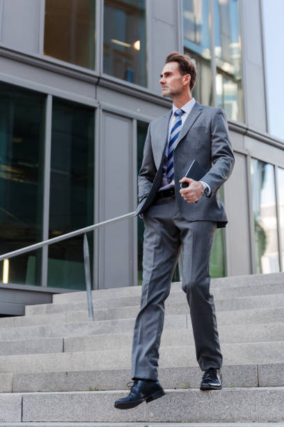 istock businessman walking downstairs in an office park 887714732