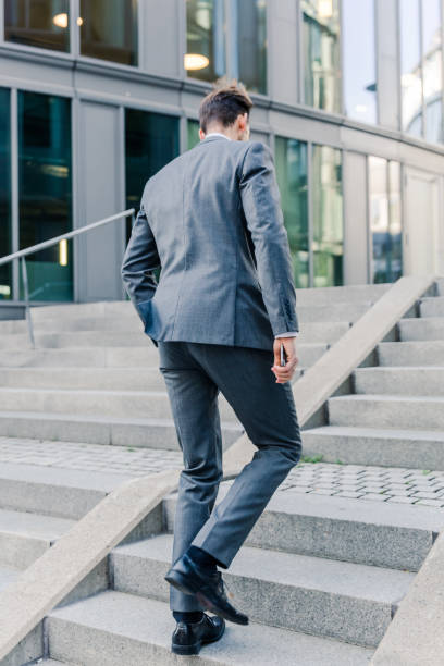istock businessman walking upstairs in an office park 887714754