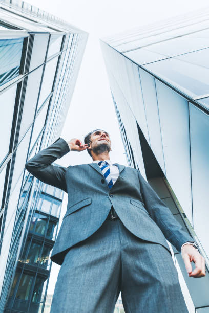 istock businessman with earphones stands between skyscrapers 887714958