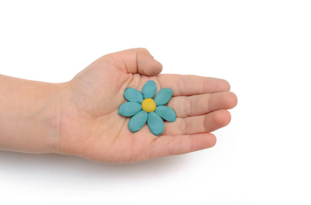 istock Plasticine flower in a child's hand on a white background 887719322