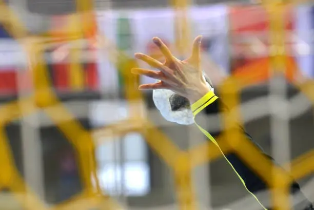 Handball saved by a female handball goalkeeper, seen from behind the net