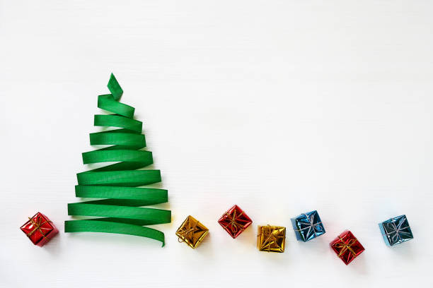 istock Christmas tree made from green ribbon with small gifts on white background. Copy space 887768262