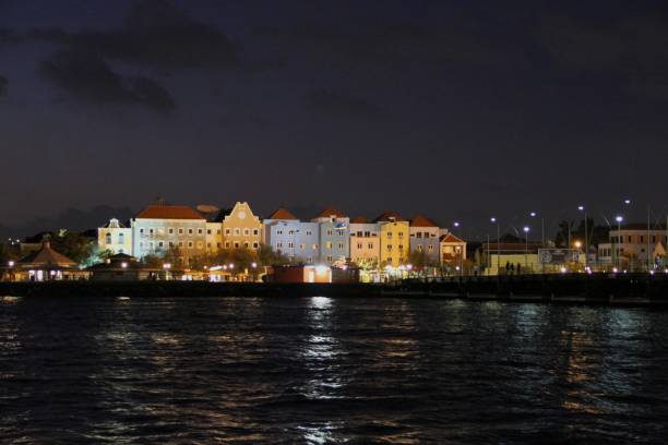 istock Illuminated Cityscape By River Against Sky At Night 887769476