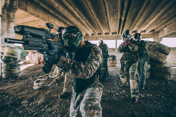 Teamwork Team of paintball players standing with their paintball guns paintballing stock pictures, royalty-free photos & images