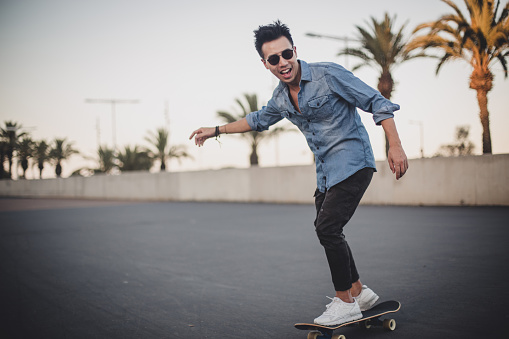 One man, young and handsome skater, riding his skateboard.