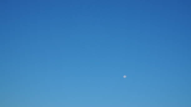 Light gradient clear blue morning sky with small white almost full round moon floating background