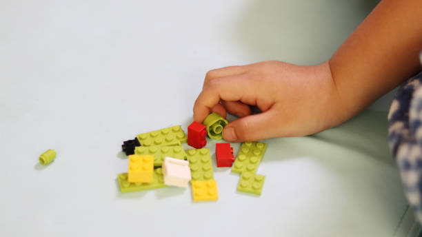 istock Hands of a child playing block toy. 887806292