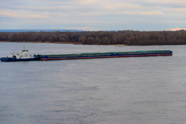 istock Tugboat pushing a heavy long barge on the river Dnieper 887806976