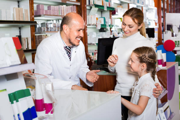 istock Male pharmacist working pharmaceutical store and consulting customers 887807436