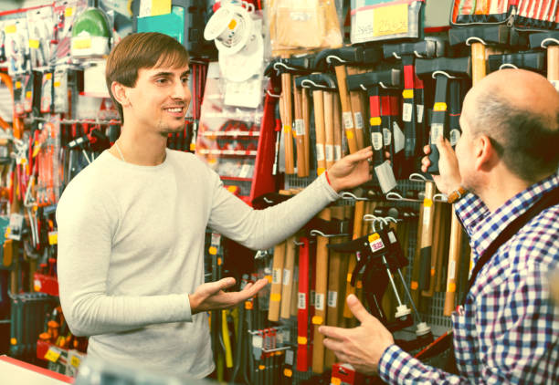 istock Ordinary customer and friendly seller choosing hammer 887807648