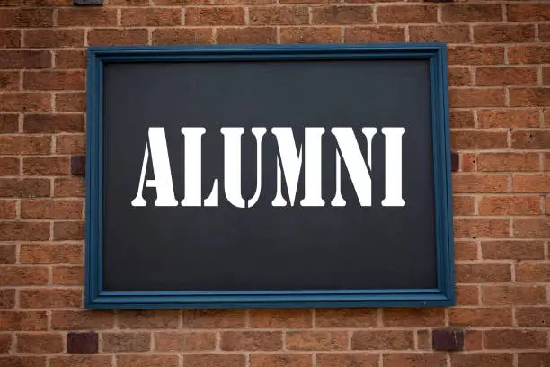 Photo of Conceptual hand writing text caption inspiration showing announcement Alumni Former Students. Business concept for  Celebration Education Ending written on frame old brick background with copy space