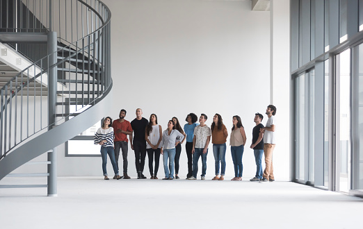 Team of a startup company with 12 people in a white and empty warehouse making their decisions.