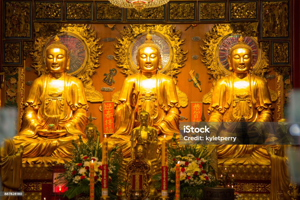 Three Gold Buddha's in a row Golden Buddha statues in a row at a palace in Thailand. Buddhism Stock Photo