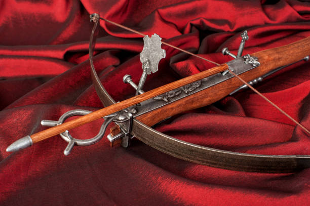 istock wooden crossbow  close-up on crimson silk background 887836132