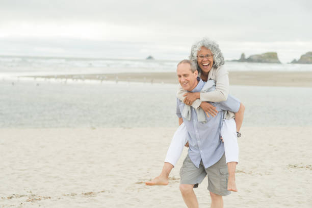 istock Cute Older Couple Walk on the Beach 887838326