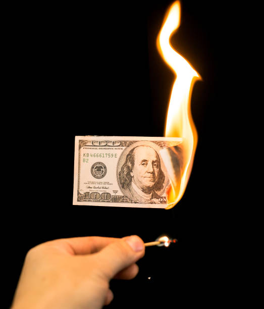 istock a hundred dollars burn in a fire on a black background 887880270