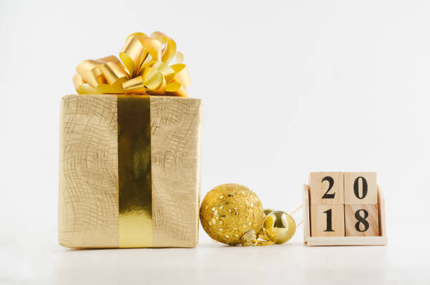istock Cube calendar for new year 2018 with golden gift box and decorations on white background 887890856