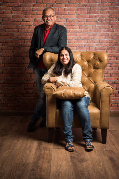 istock indian gold couple sitting on sofa 887924046