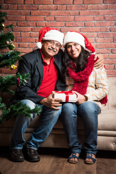 istock indian senior couple exchanging christmas gift while sitting on sofa 887927912