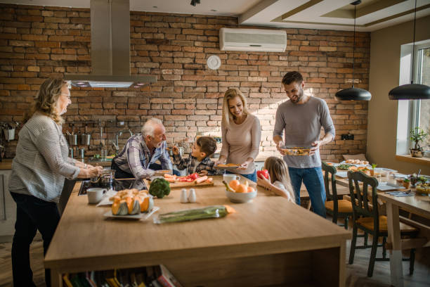 istock Happy extended family enjoying while making lunch together in the kitchen. 887944728