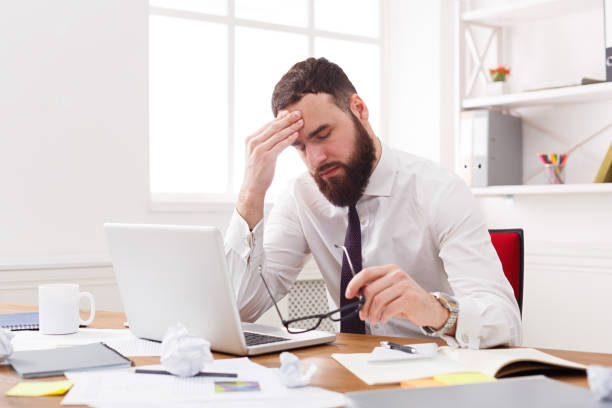 istock Stressed businessman with laptop in modern white office 887960142