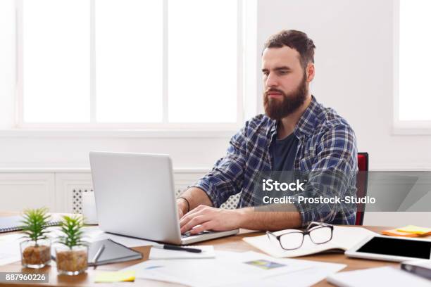 Young Concentrated Businessman With Laptop In Modern White Office Stock Photo - Download Image Now