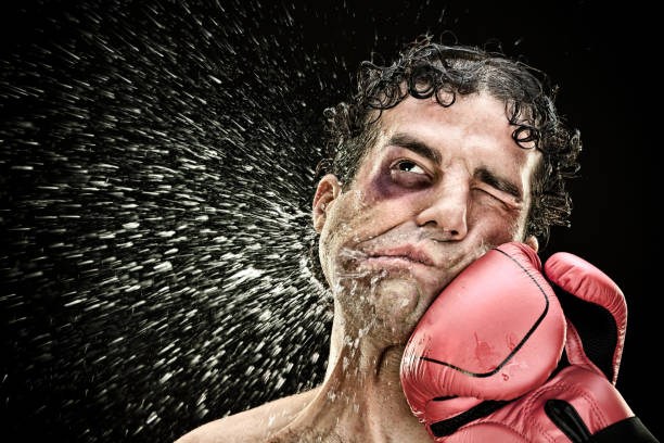 silly boxer man takes a punch in the face isolated on black.funny concept portrait silly boxer man takes a punch in the face isolated on black.funny concept portrait. punch stock pictures, royalty-free photos & images