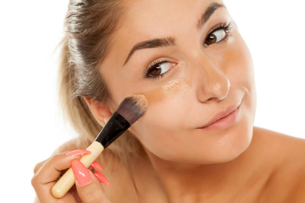 istock young beautiful woman applied liquid base with a brush 887960568
