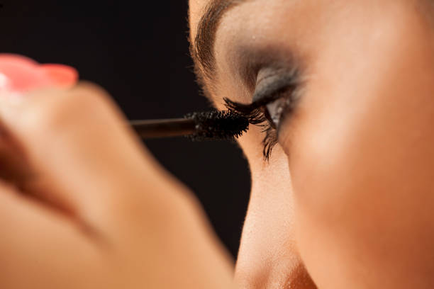 istock young woman applying a mascara to her eyelashes 887960584