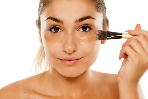 istock young beautiful woman applied liquid base with a brush 887960590