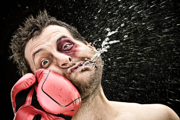 silly boxer man takes a punch in the face isolated on black.funny concept portrait silly boxer man takes a punch in the face isolated on black.funny concept portrait. violence boxing fighting combative sport stock pictures, royalty-free photos & images