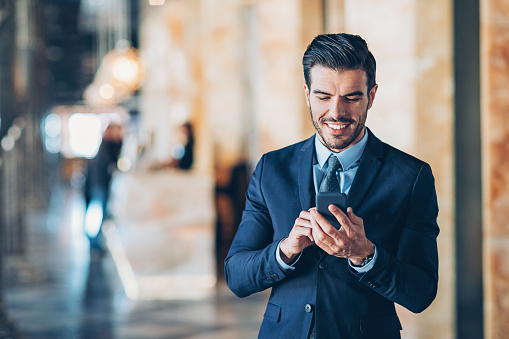 Businessman using mobile phone in a hotel's lobby