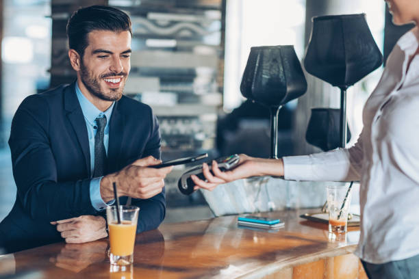 istock Businessman making contactless payment in a hotel's bar 887964832