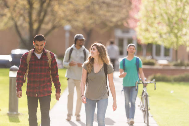 istock College students hang out in between classes on sidewalk, talking and smiling 887965472